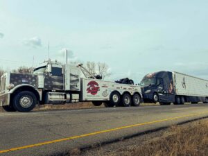All American Towing heavy duty wrecker towing a tractor trailer on the highway in San Antonio